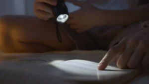 A Person Using a Flashlight on a Book