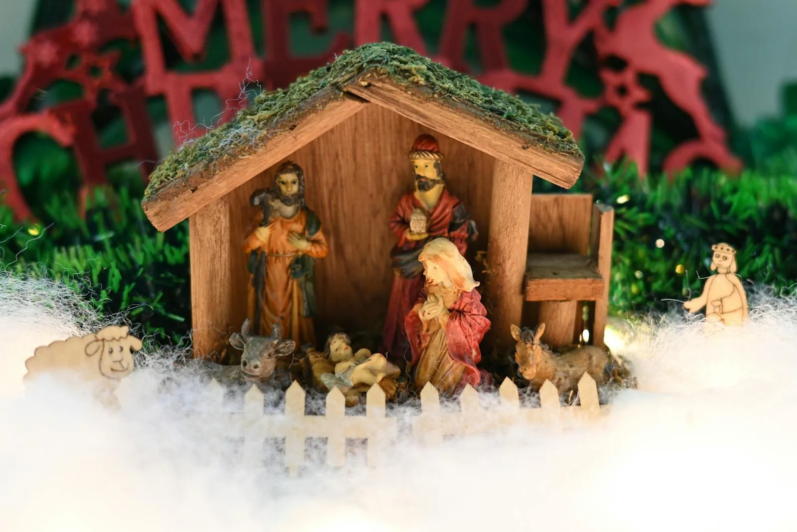 A close-up of a traditional wooden nativity scene with figurines depicting the birth of Jesus.