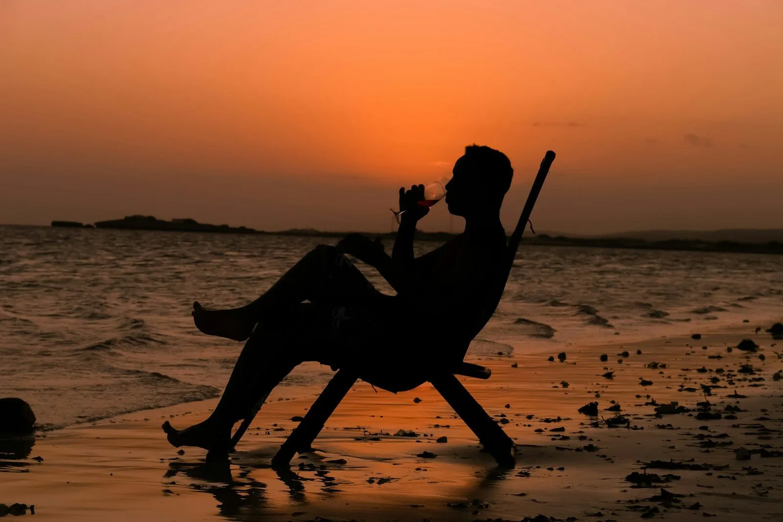 a person sitting in a chair on the beach
