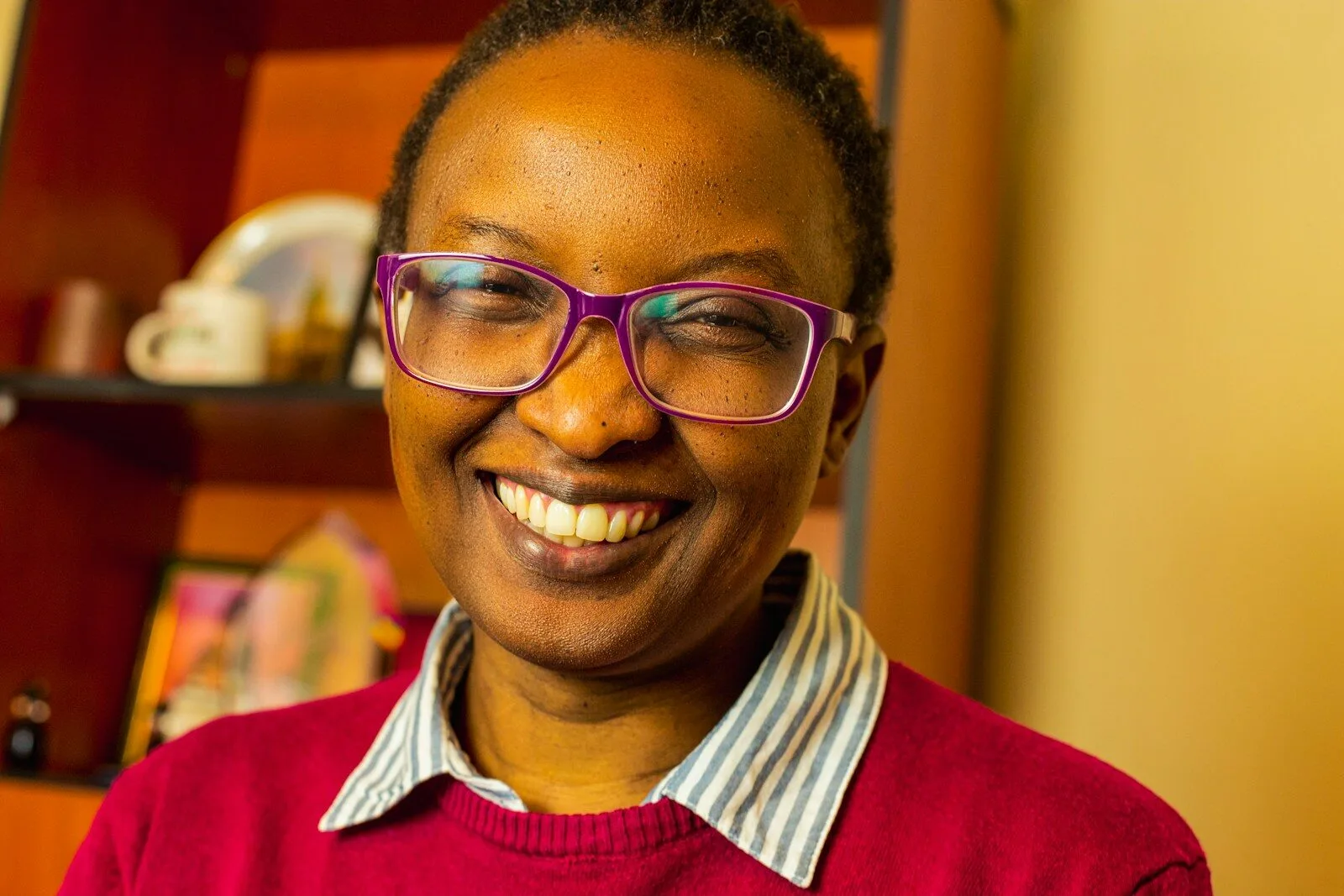 a woman with glasses smiling for the camera