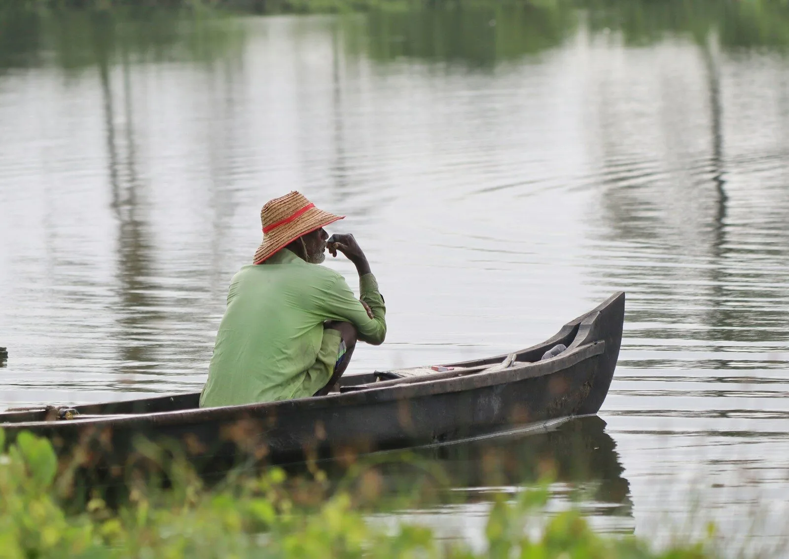 a man sitting in a canoe on a lake