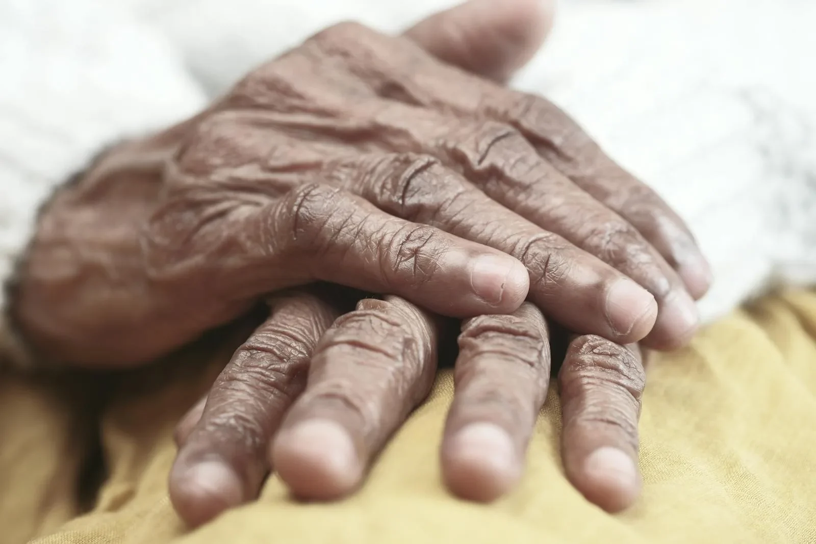 Close-up image of senior adult hands resting, showcasing texture and character.